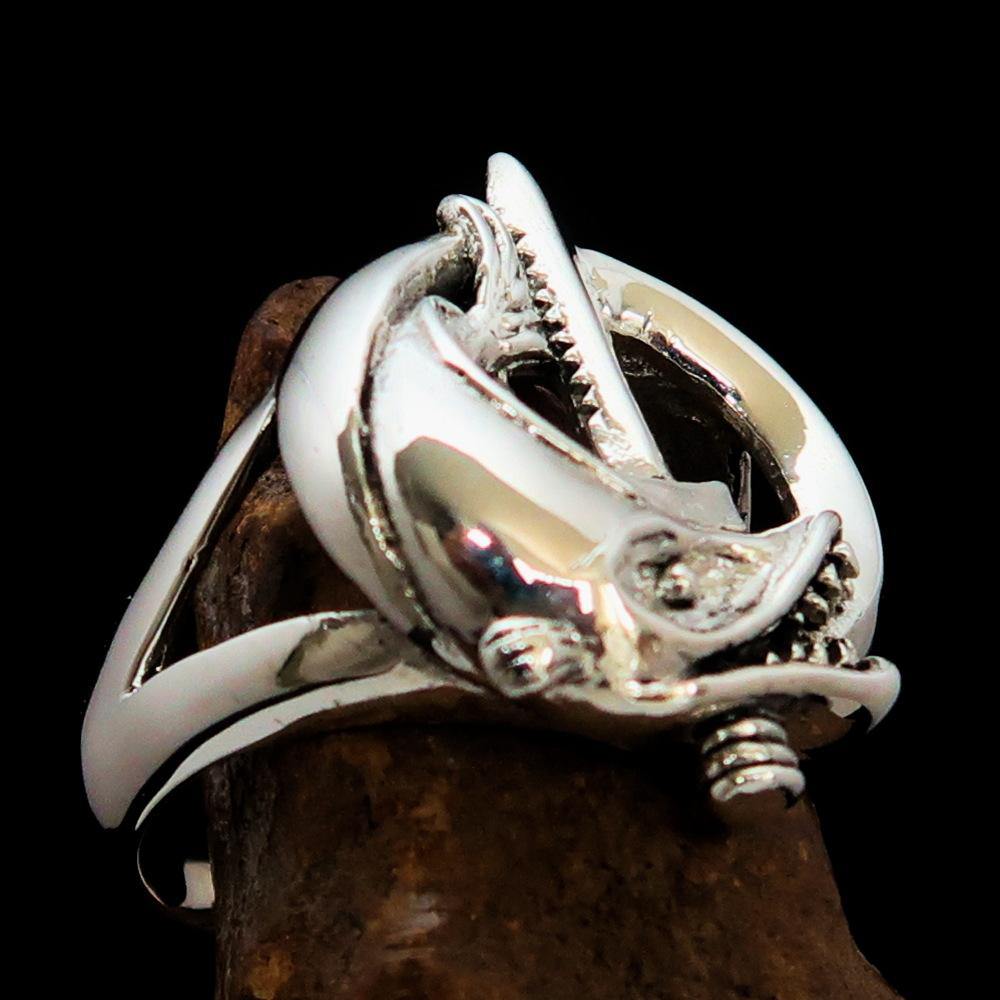 A beautifully crafted sterling silver ring featuring intricate fish and sword designs, showcasing a high polished finish.