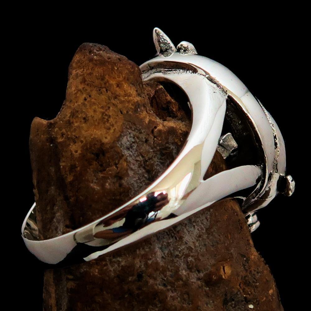 A beautifully crafted sterling silver ring featuring intricate fish and sword designs, showcasing a high polished finish.