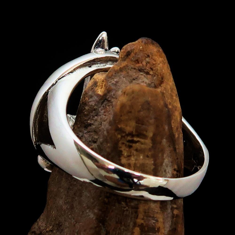 A beautifully crafted sterling silver ring featuring intricate fish and sword designs, showcasing a high polished finish.