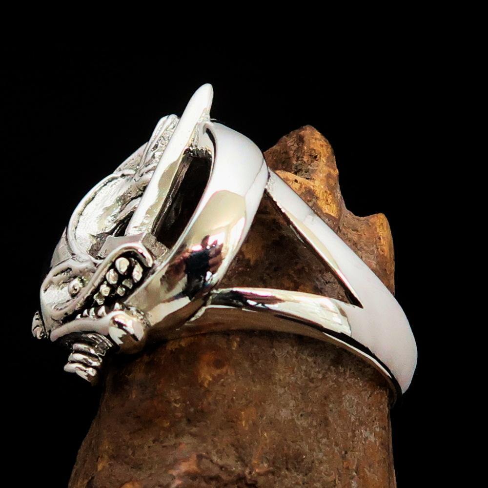 A beautifully crafted sterling silver ring featuring intricate fish and sword designs, showcasing a high polished finish.