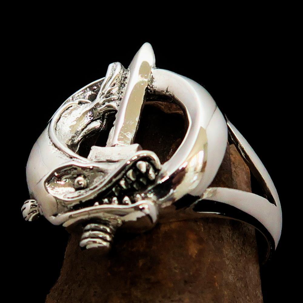 A beautifully crafted sterling silver ring featuring intricate fish and sword designs, showcasing a high polished finish.