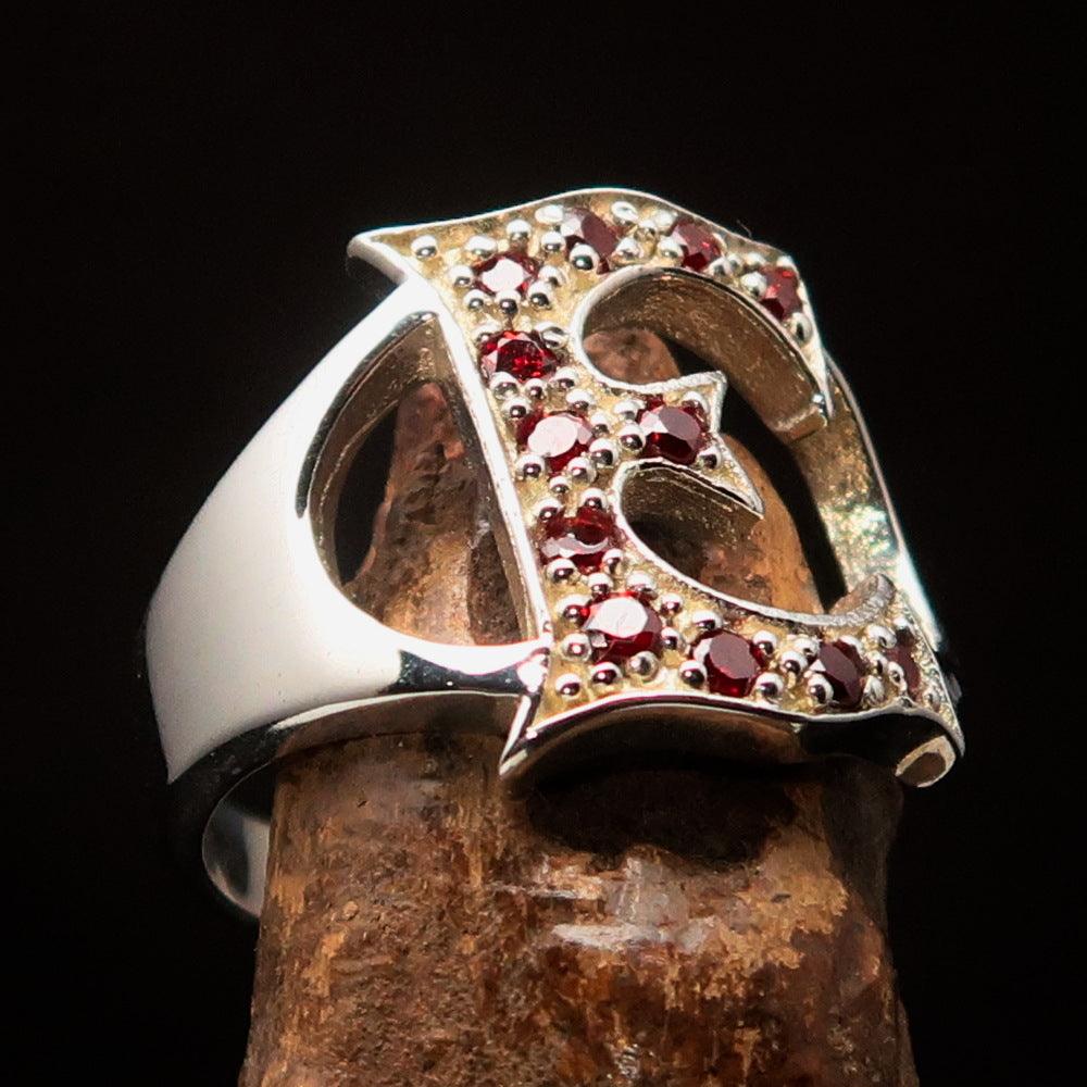 A beautifully crafted Sterling Silver Initial Ring featuring a bold letter E adorned with 12 red Cubic Zirconias, showcasing elegance and style.