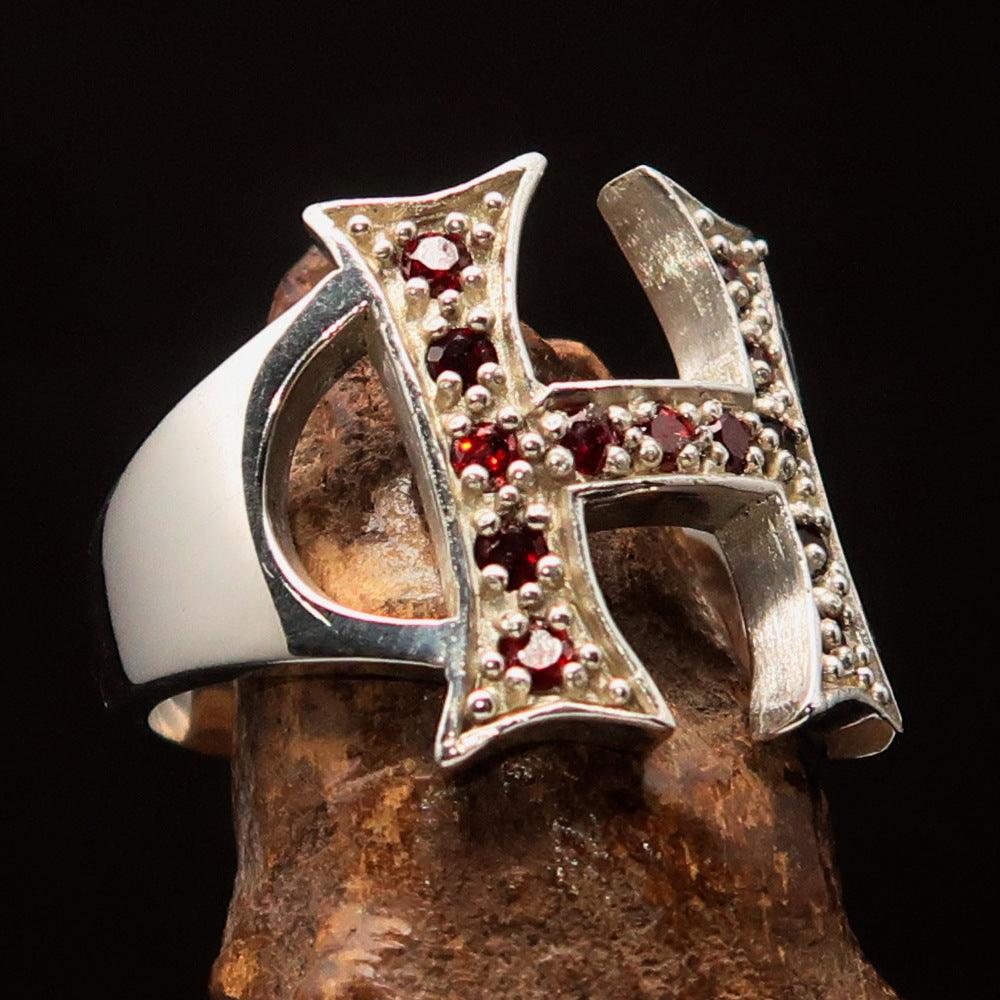 A beautifully crafted sterling silver ring featuring a bold letter H adorned with 13 red cubic zirconias, showcasing luxury and elegance.