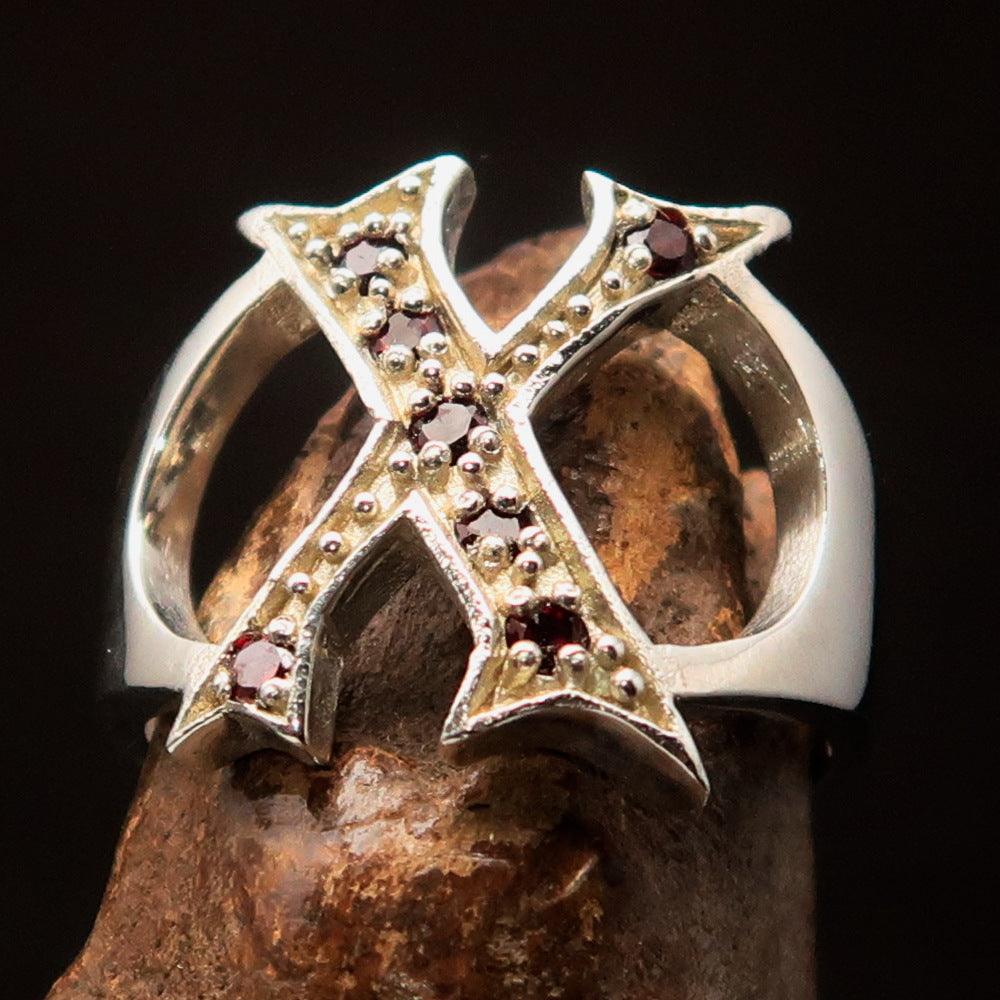 A bold sterling silver initial ring featuring the letter X, adorned with 7 vibrant red cubic zirconia stones, showcasing its elegant design.