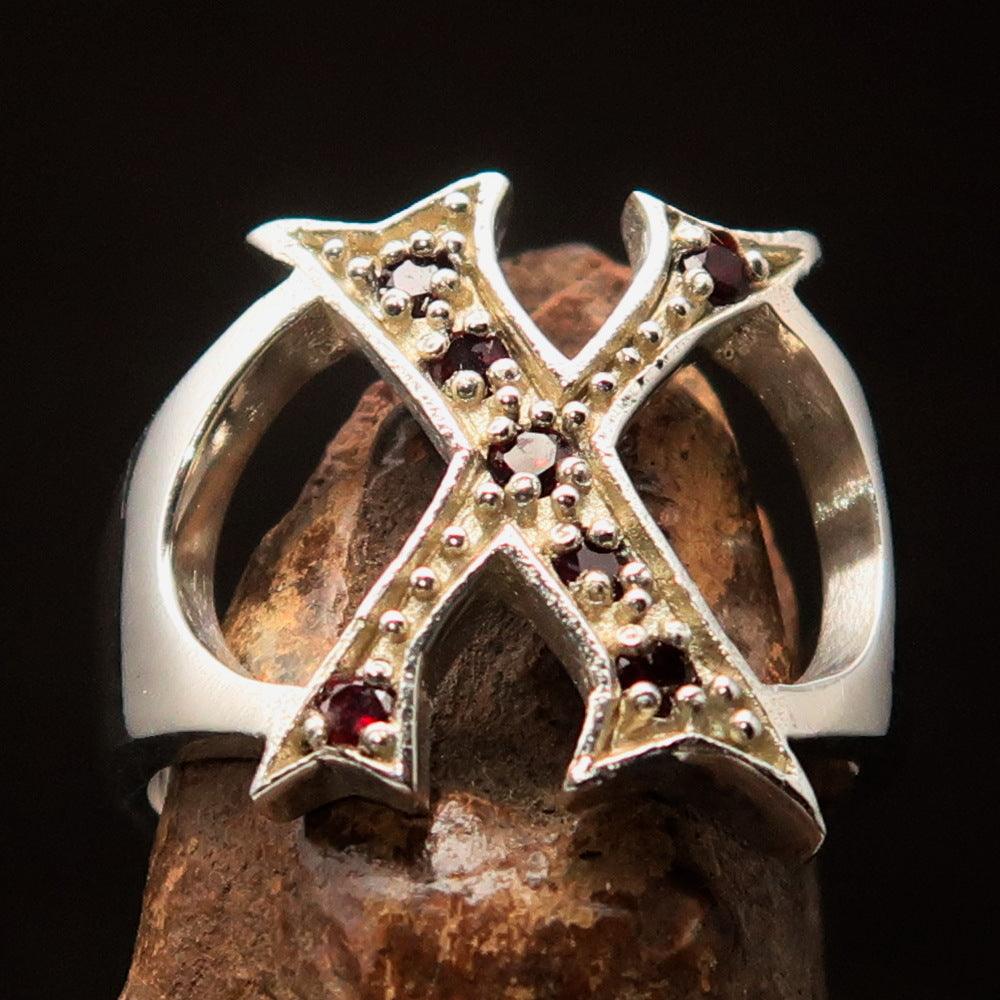 A bold sterling silver initial ring featuring the letter X, adorned with 7 vibrant red cubic zirconia stones, showcasing its elegant design.