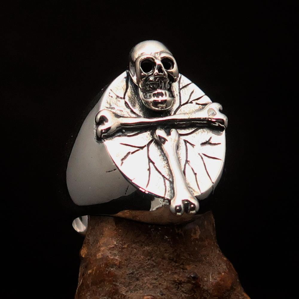 Men's sterling silver ring featuring a bone cross and R.I.P skull design, showcasing intricate craftsmanship and a polished finish.