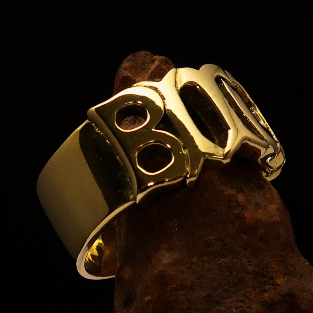 A high polished solid brass ring featuring the word 'Bitch', measuring 12 mm wide, showcasing its elegant design.