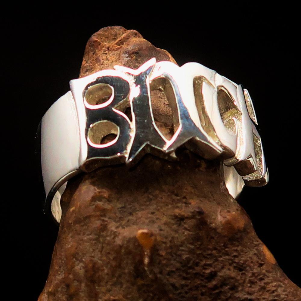 A high-polished sterling silver ring featuring the word 'Bitch', hallmarked 925, showcasing its bold design and craftsmanship.