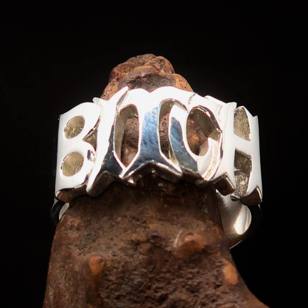 A high-polished sterling silver ring featuring the word 'Bitch', hallmarked 925, showcasing its bold design and craftsmanship.