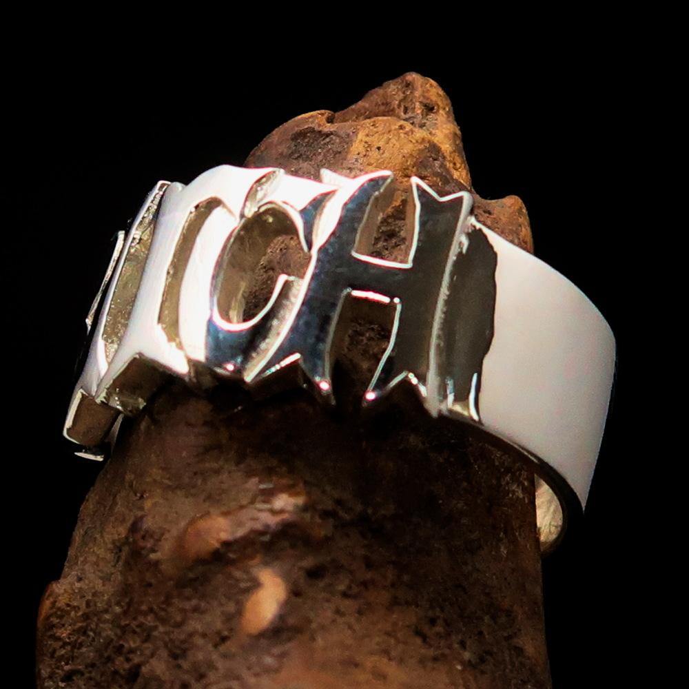 A high-polished sterling silver ring featuring the word 'Bitch', hallmarked 925, showcasing its bold design and craftsmanship.