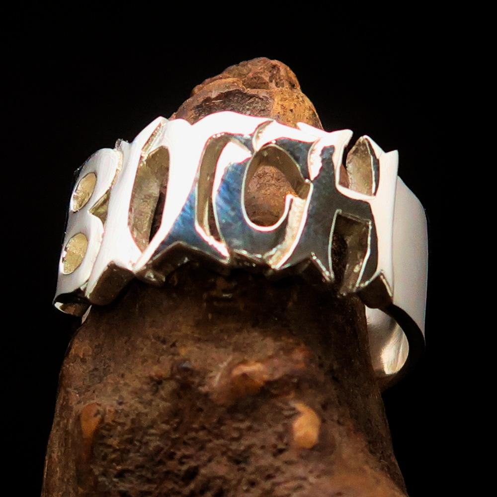 A high-polished sterling silver ring featuring the word 'Bitch', hallmarked 925, showcasing its bold design and craftsmanship.