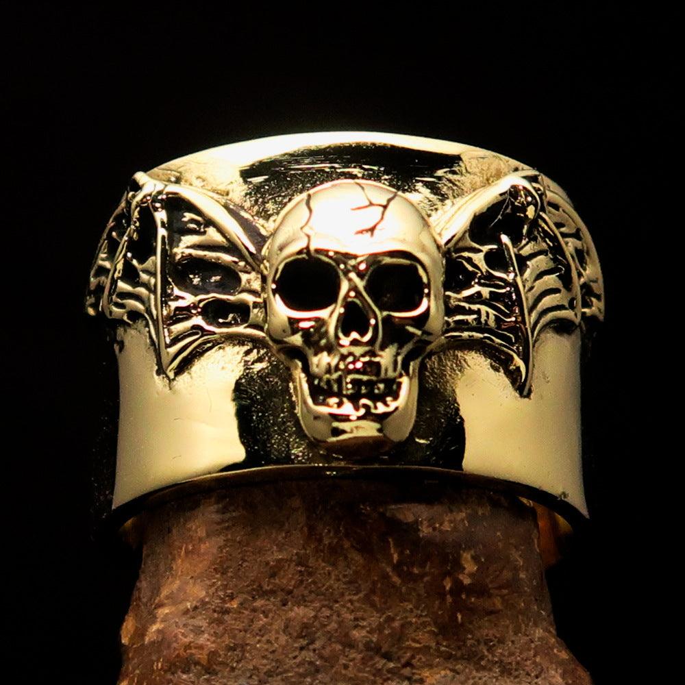 A beautifully crafted winged Bat Skull Ring made of antiqued brass, featuring intricate details on the bat skull and wings.