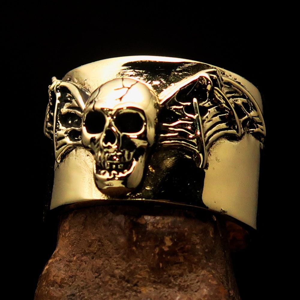 A beautifully crafted winged Bat Skull Ring made of antiqued brass, featuring intricate details on the bat skull and wings.