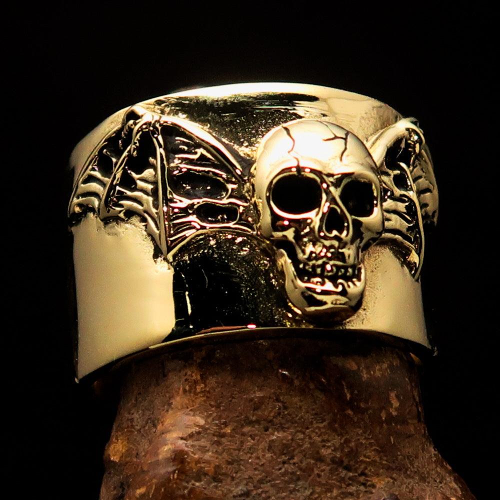 A beautifully crafted winged Bat Skull Ring made of antiqued brass, featuring intricate details on the bat skull and wings.