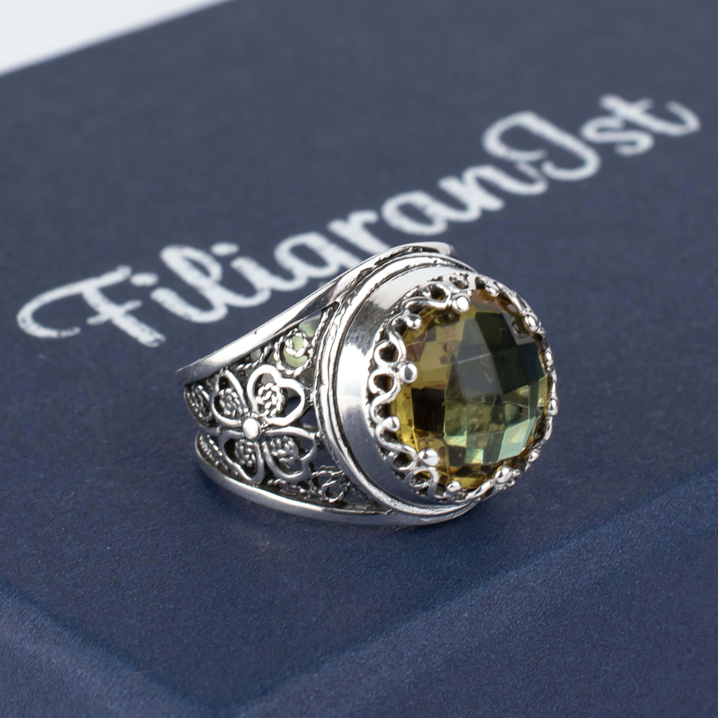 A stunning sterling silver statement ring featuring a lab-created Alexandrite gemstone in a delicate filigree design.