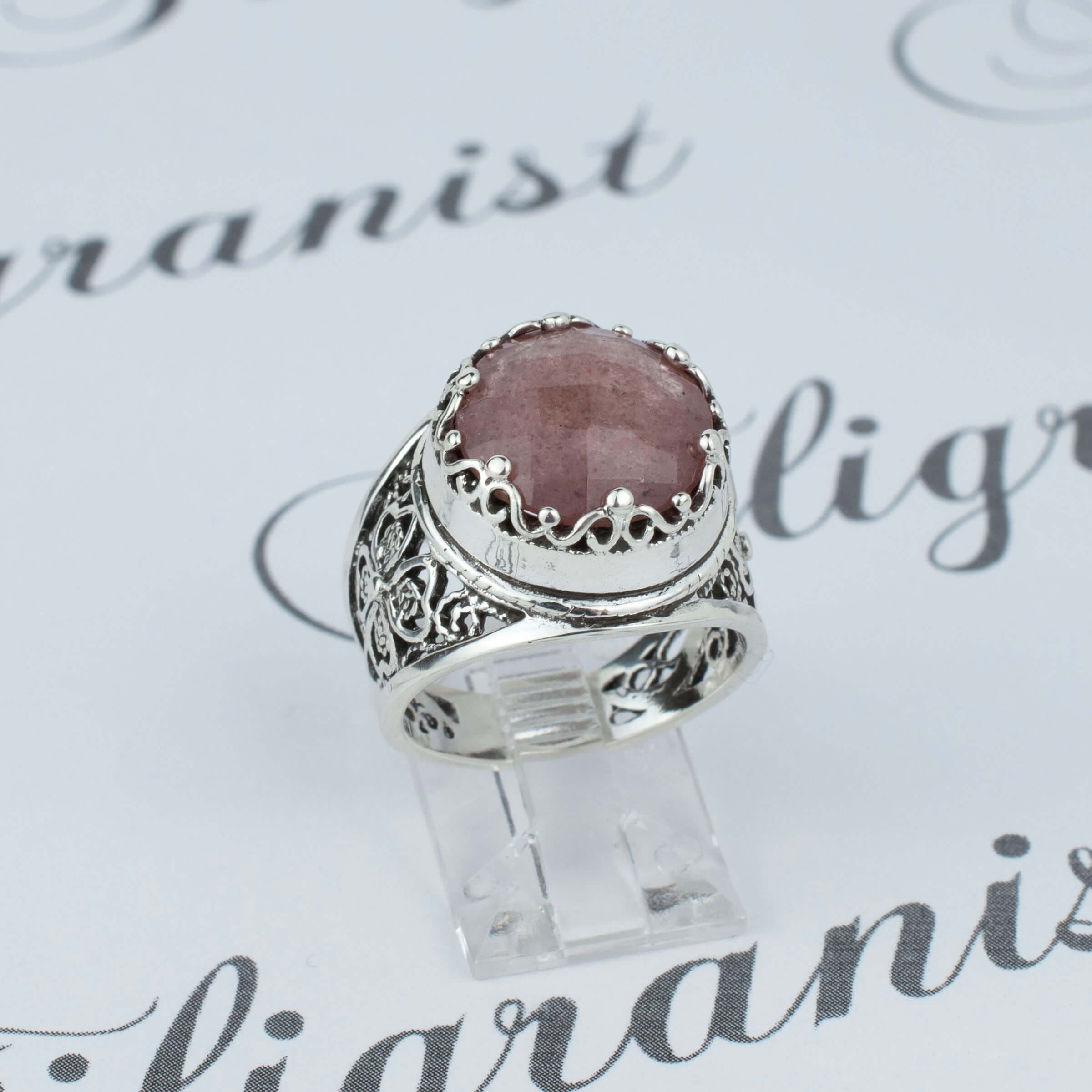 A stunning sterling silver filigree ring featuring a 12mm cherry quartz gemstone, elegantly designed with intricate metalwork.