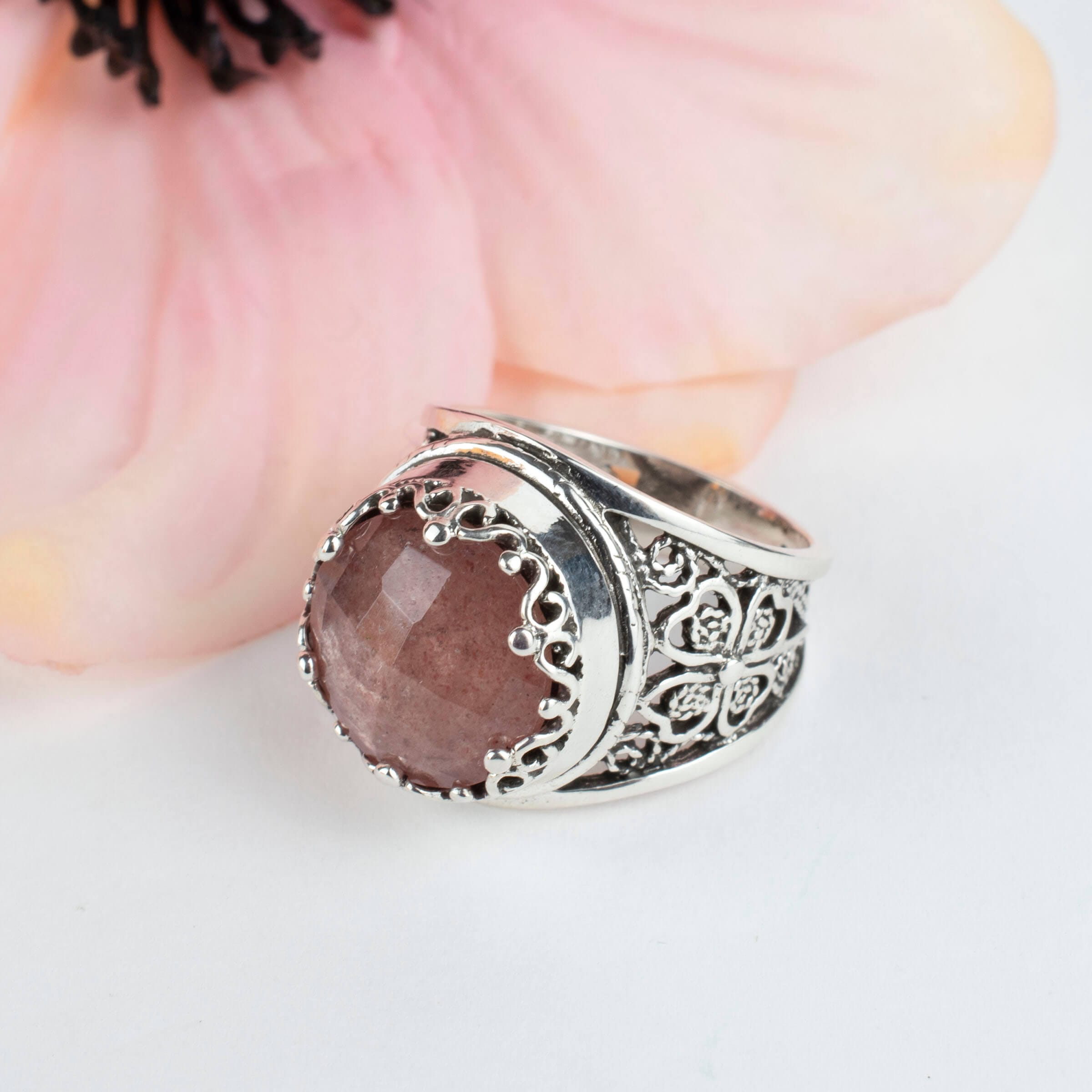 A stunning sterling silver filigree ring featuring a 12mm cherry quartz gemstone, elegantly designed with intricate metalwork.