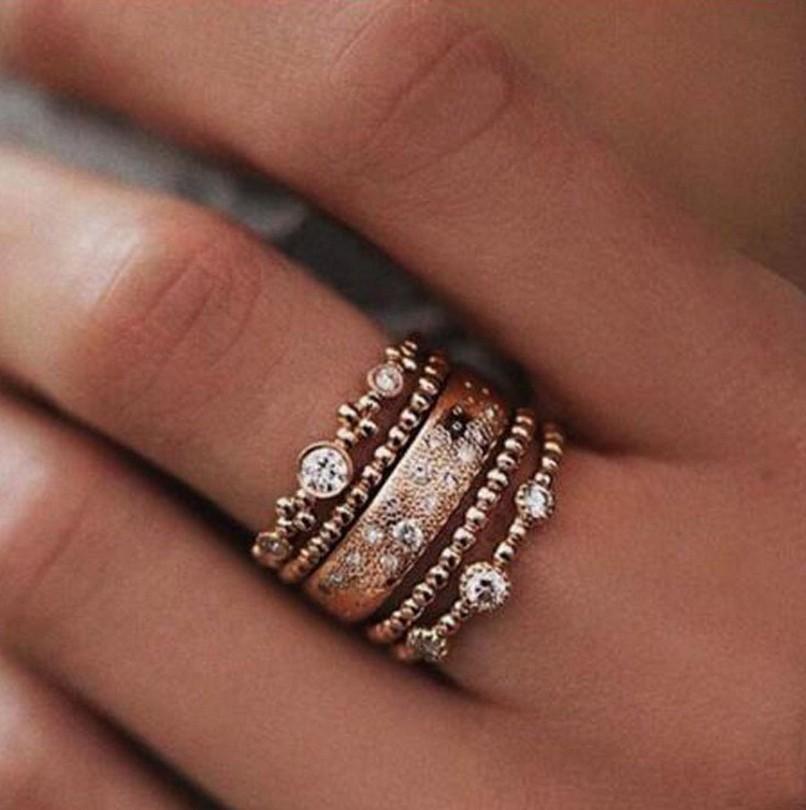 Five Piece Rose Gold Ring Set featuring a thicker band with crystals and four thin bands, elegantly displayed.