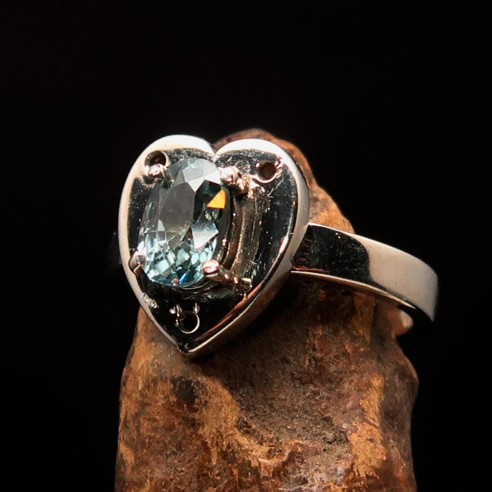 Heart shaped sterling silver solitaire ring featuring an oval cut blue zircon gemstone, polished to a mirror finish.