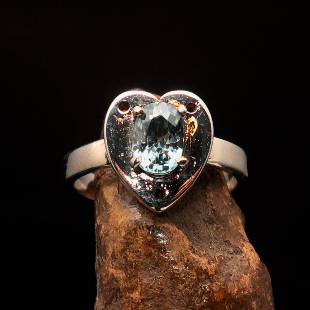 Heart shaped sterling silver solitaire ring featuring an oval cut blue zircon gemstone, polished to a mirror finish.