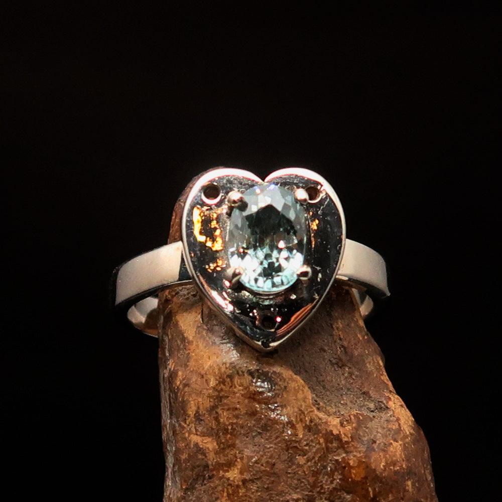 Heart shaped sterling silver solitaire ring featuring an oval cut blue zircon gemstone, polished to a mirror finish.