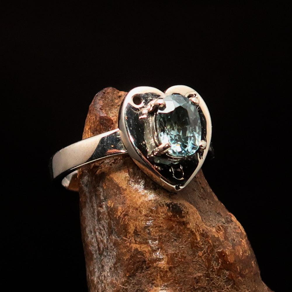 Heart shaped sterling silver solitaire ring featuring an oval cut blue zircon gemstone, polished to a mirror finish.