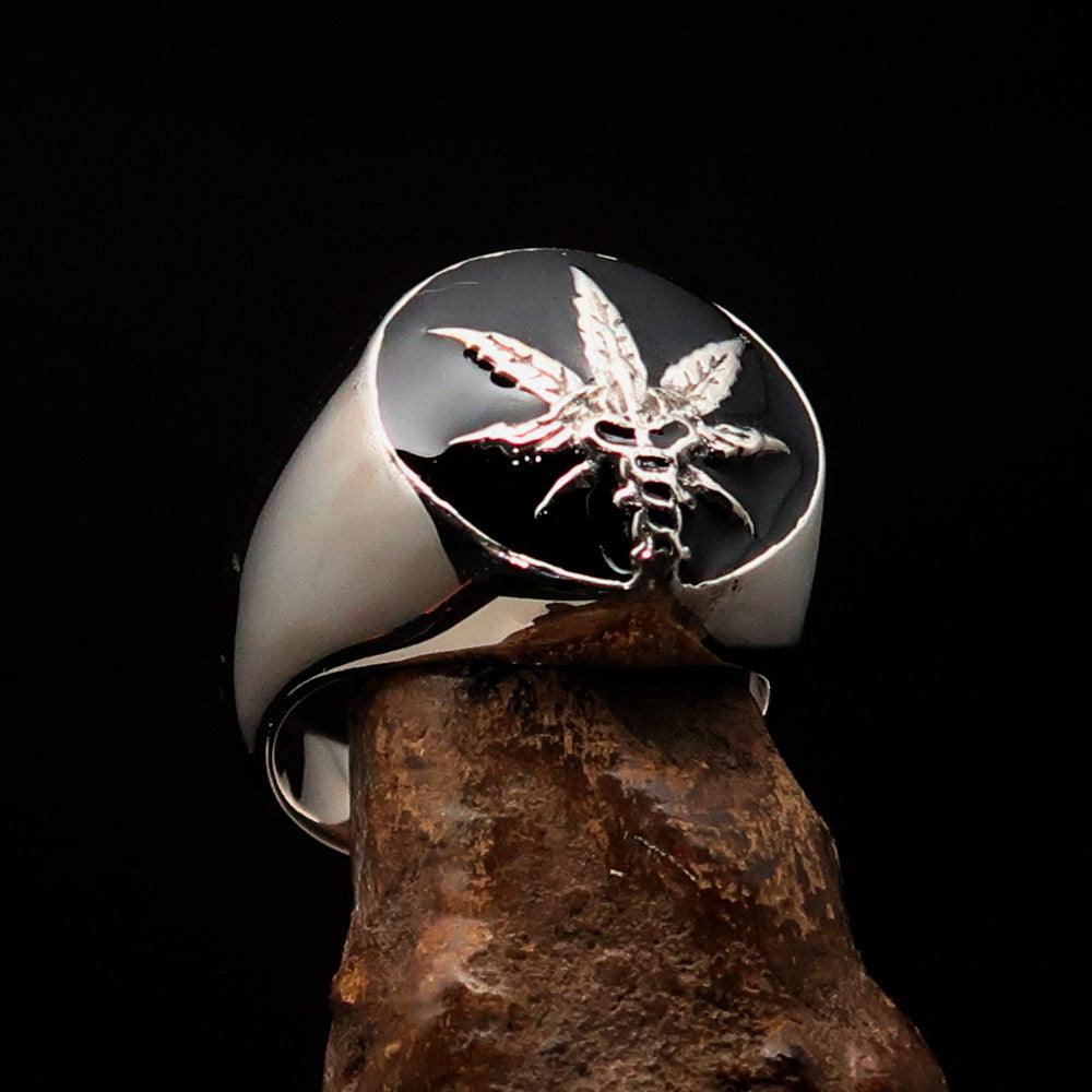 Men's sterling silver ring with a cannabis leaf symbol and black enamel finish, showcasing a polished design.