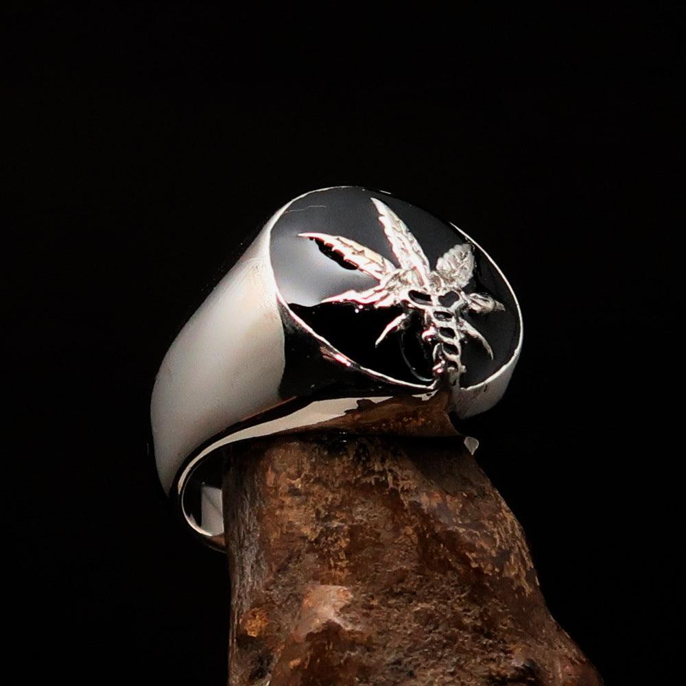 Men's sterling silver ring with a cannabis leaf symbol and black enamel finish, showcasing a polished design.