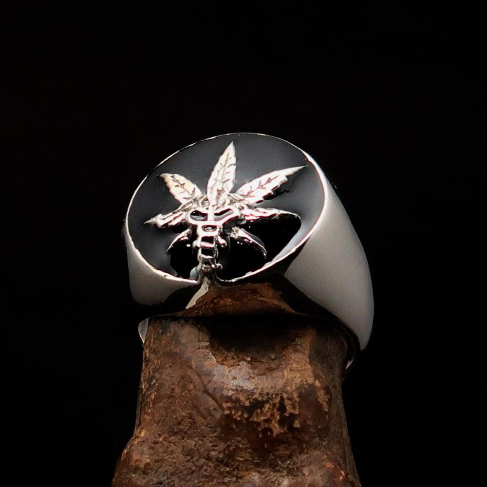 Men's sterling silver ring with a cannabis leaf symbol and black enamel finish, showcasing a polished design.