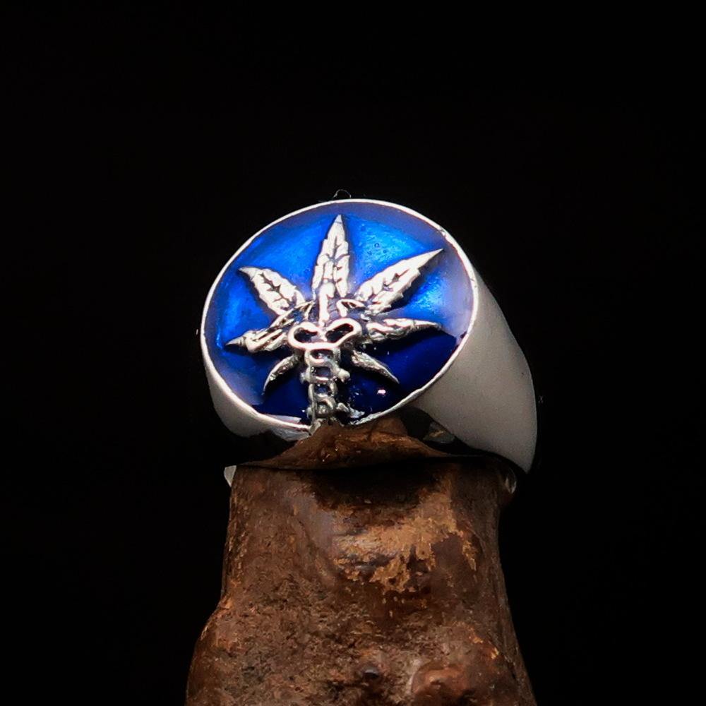 Men's sterling silver ring featuring a cannabis leaf symbol with blue enamel, showcasing a polished finish and unique design.