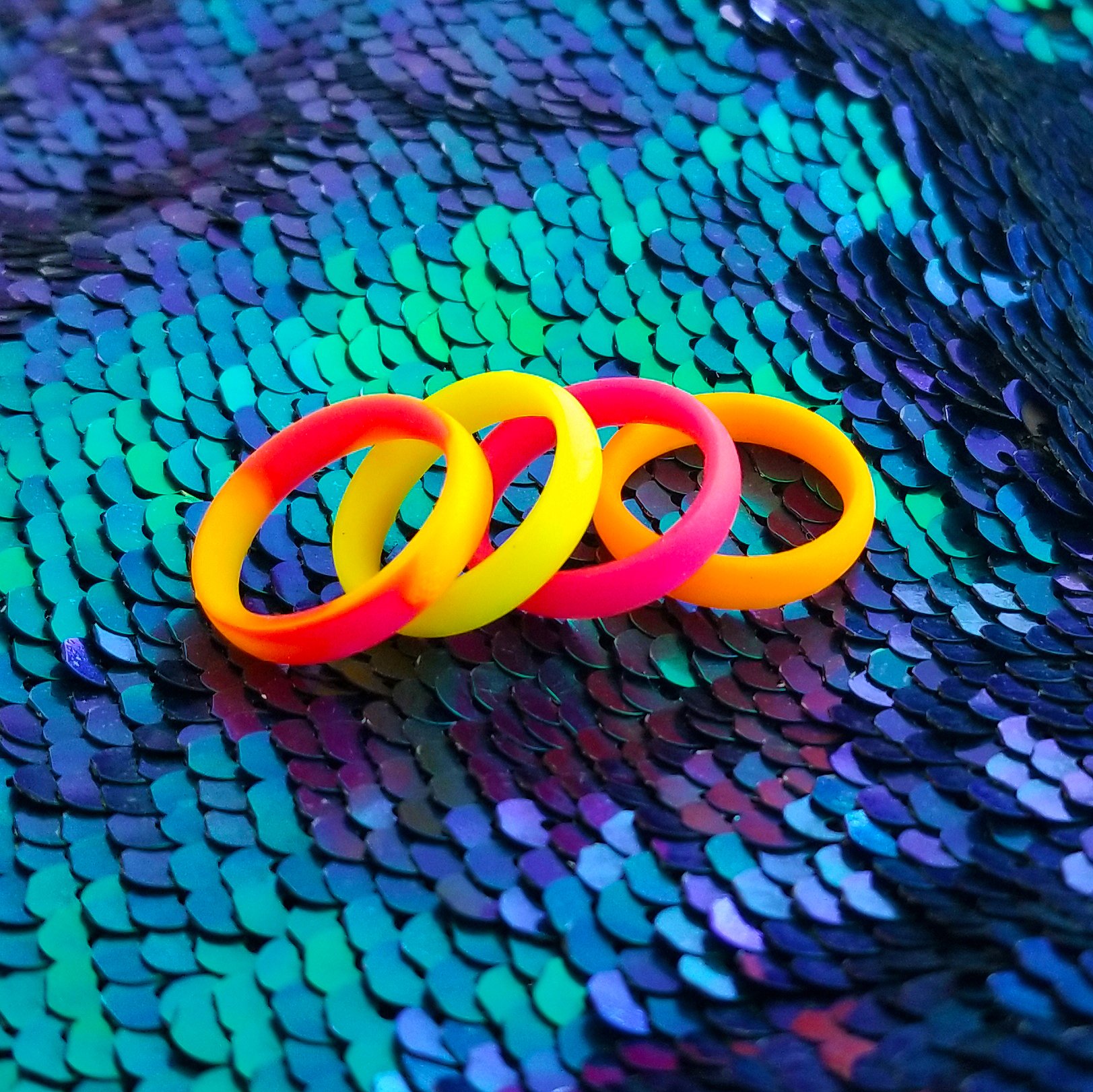 Vibrant neon orange, yellow, and pink swirl silicone ring with a sleek bevel design, showcasing its breathable and comfortable fit.