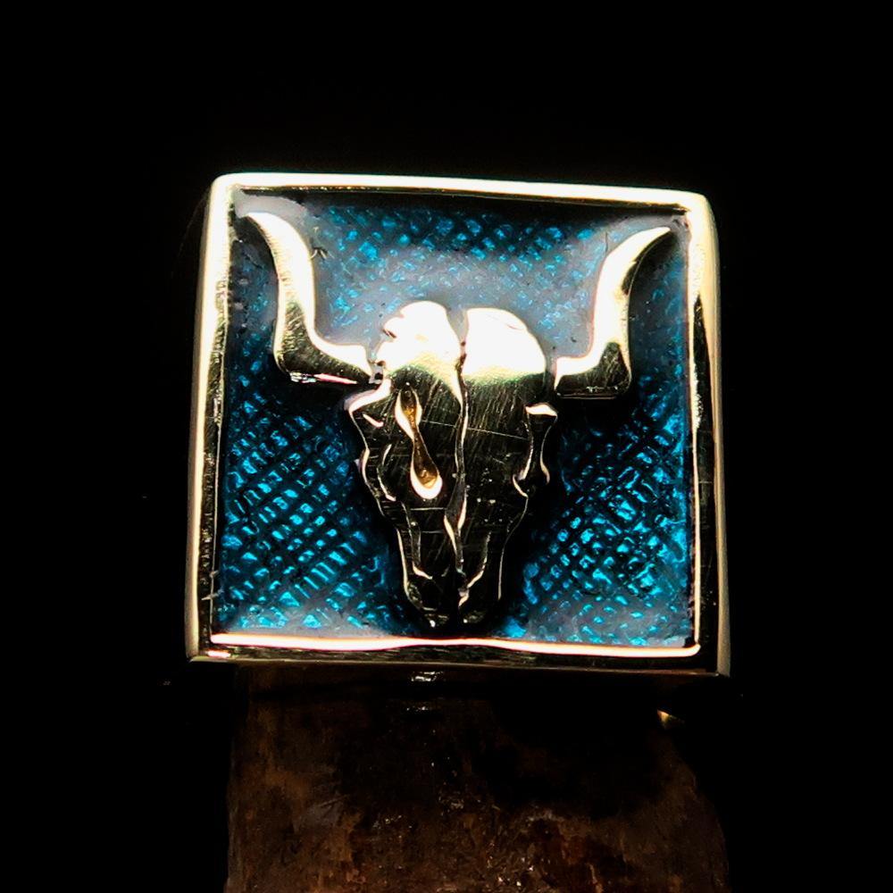 Men's Cowboy Ring featuring a bull skull design in solid brass with blue enamel accents, showcasing intricate details and a polished finish.