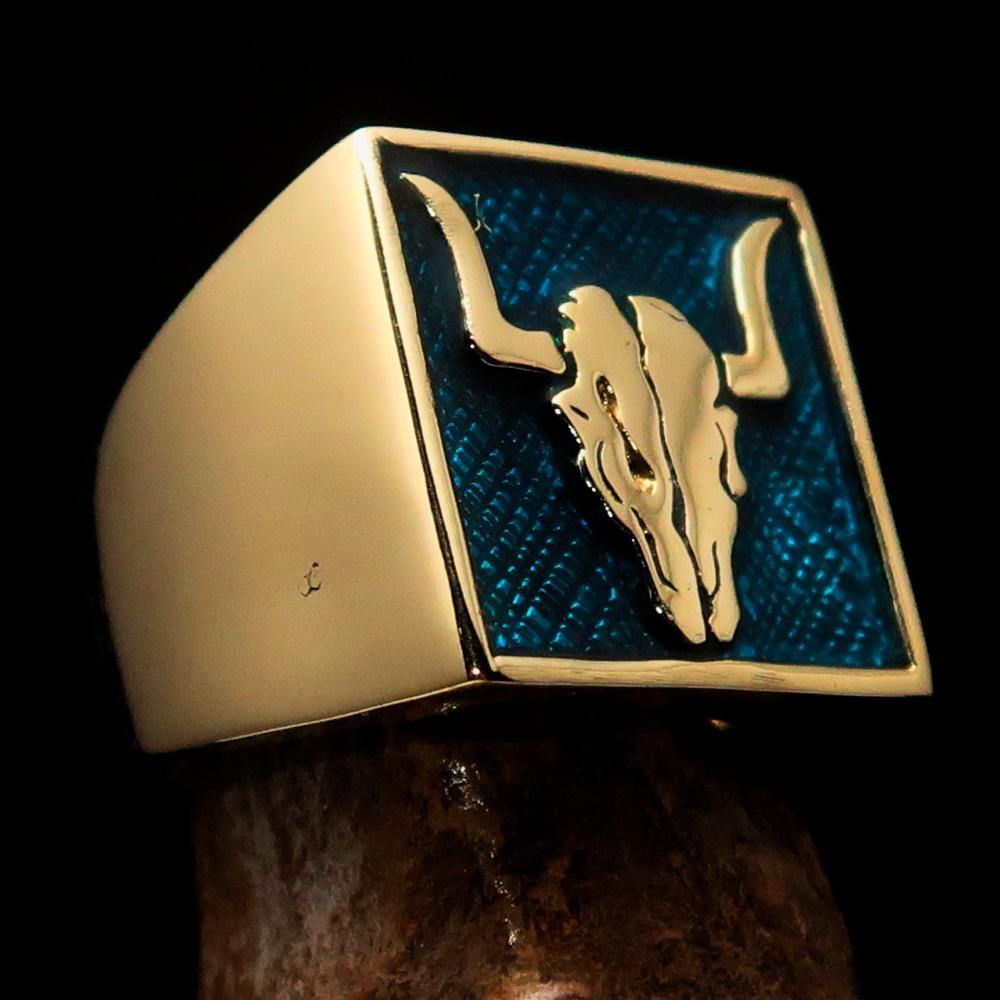 Men's Cowboy Ring featuring a bull skull design in solid brass with blue enamel accents, showcasing intricate details and a polished finish.