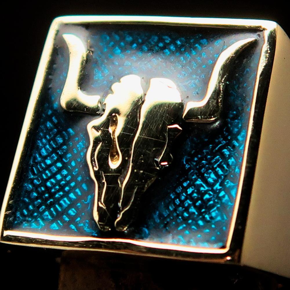 Men's Cowboy Ring featuring a bull skull design in solid brass with blue enamel accents, showcasing intricate details and a polished finish.