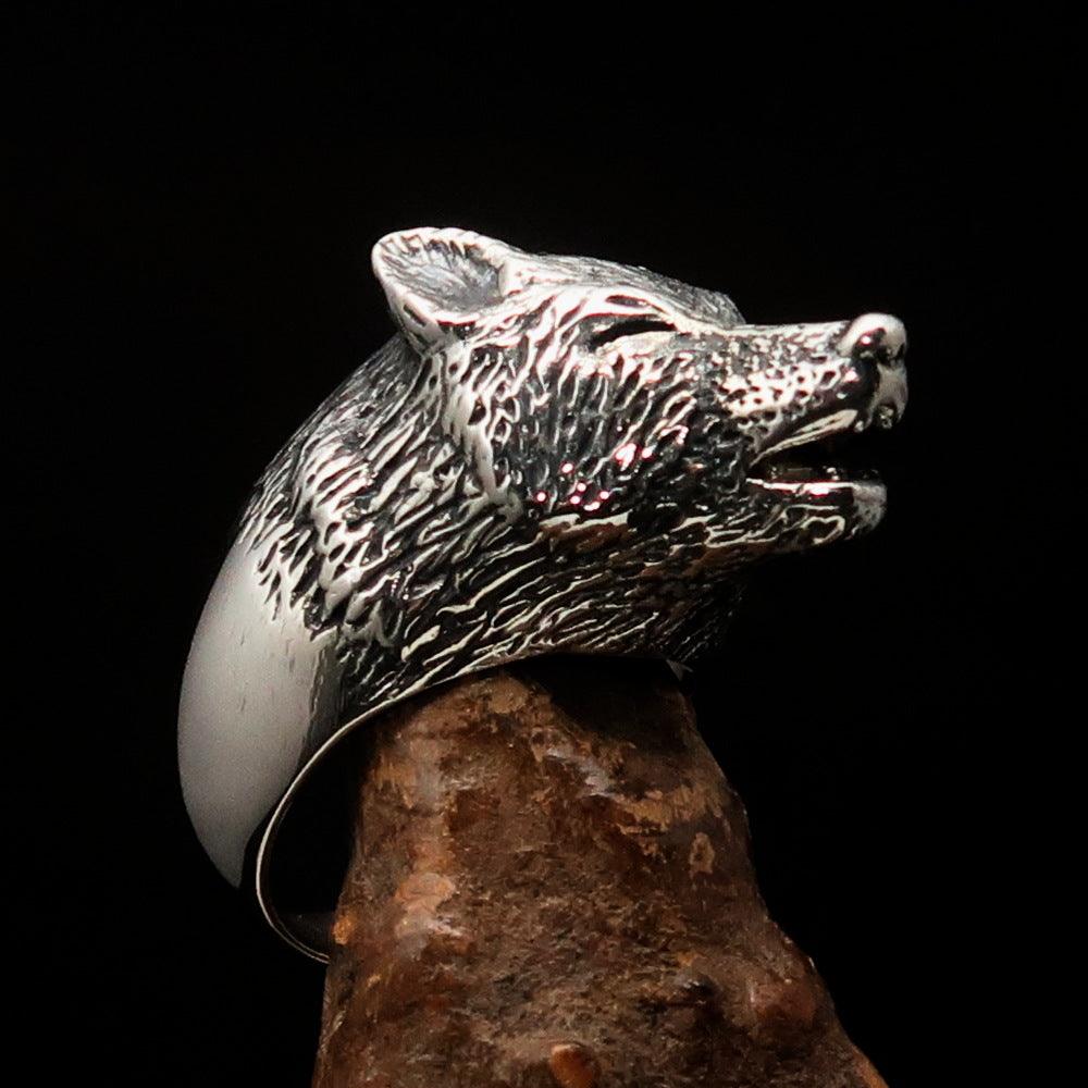 Men's howling wolf ring made of antiqued sterling silver, showcasing intricate detailing and a polished finish.