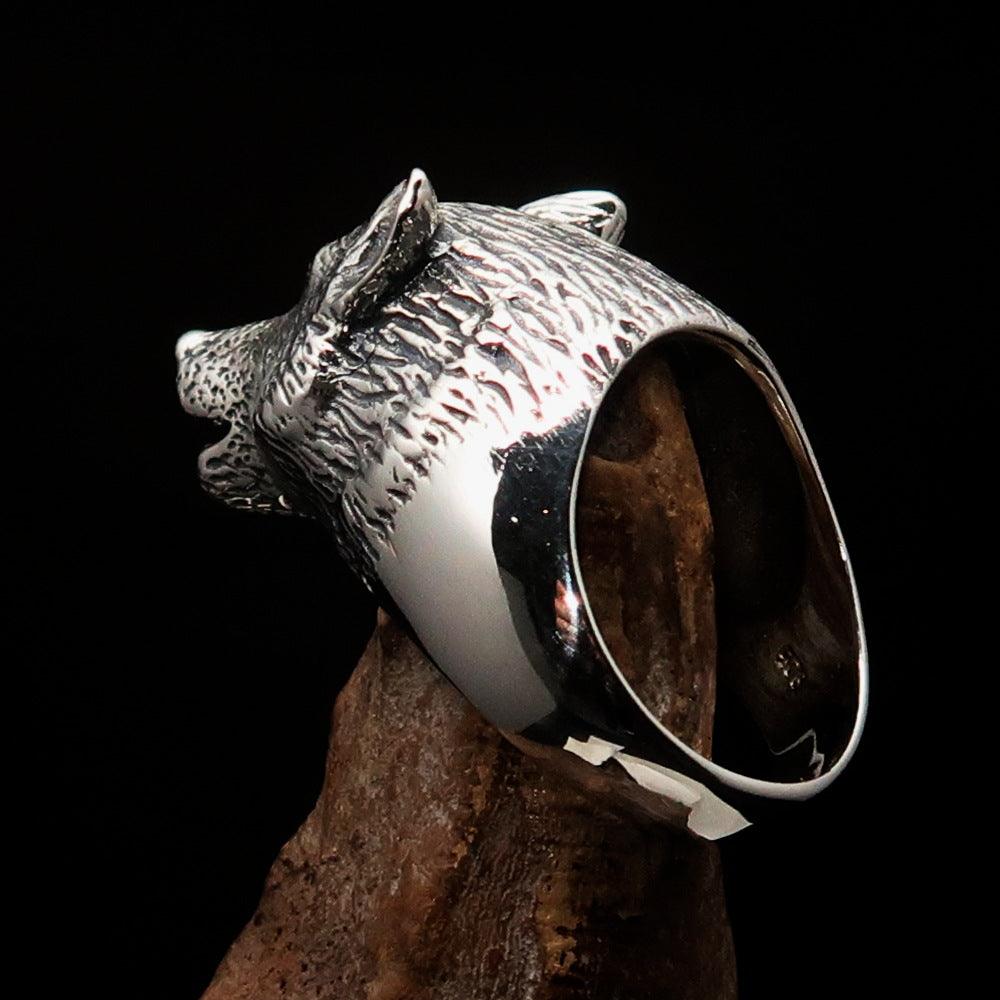 Men's howling wolf ring made of antiqued sterling silver, showcasing intricate detailing and a polished finish.