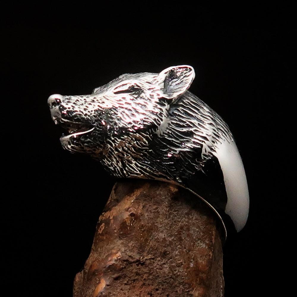 Men's howling wolf ring made of antiqued sterling silver, showcasing intricate detailing and a polished finish.