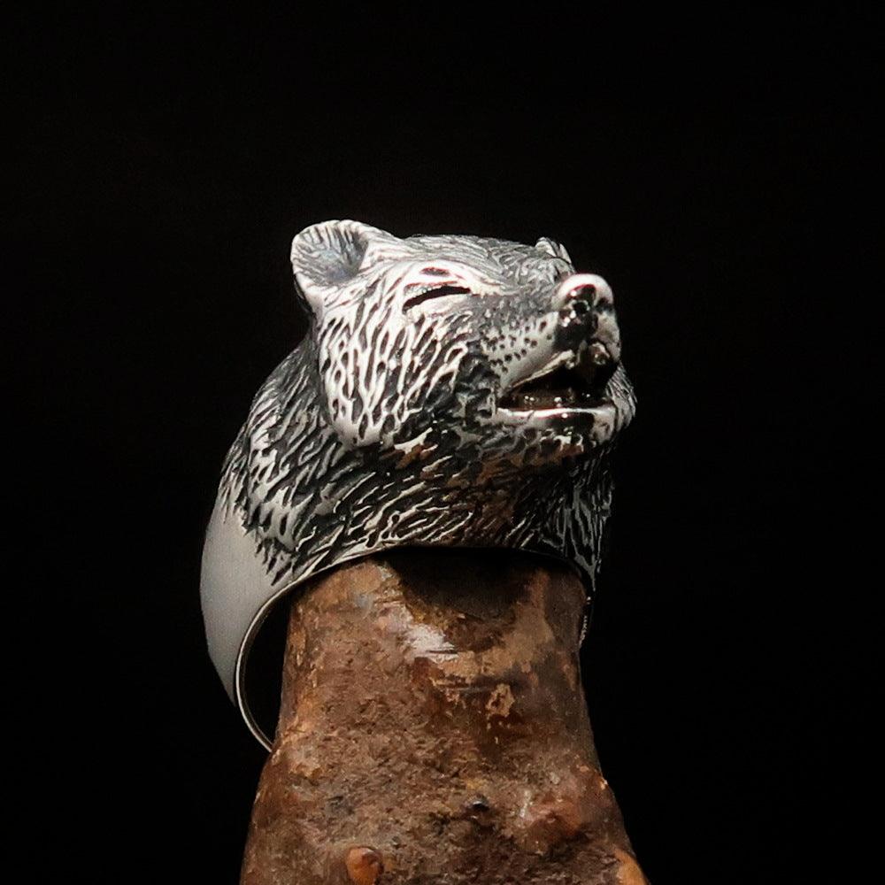 Men's howling wolf ring made of antiqued sterling silver, showcasing intricate detailing and a polished finish.