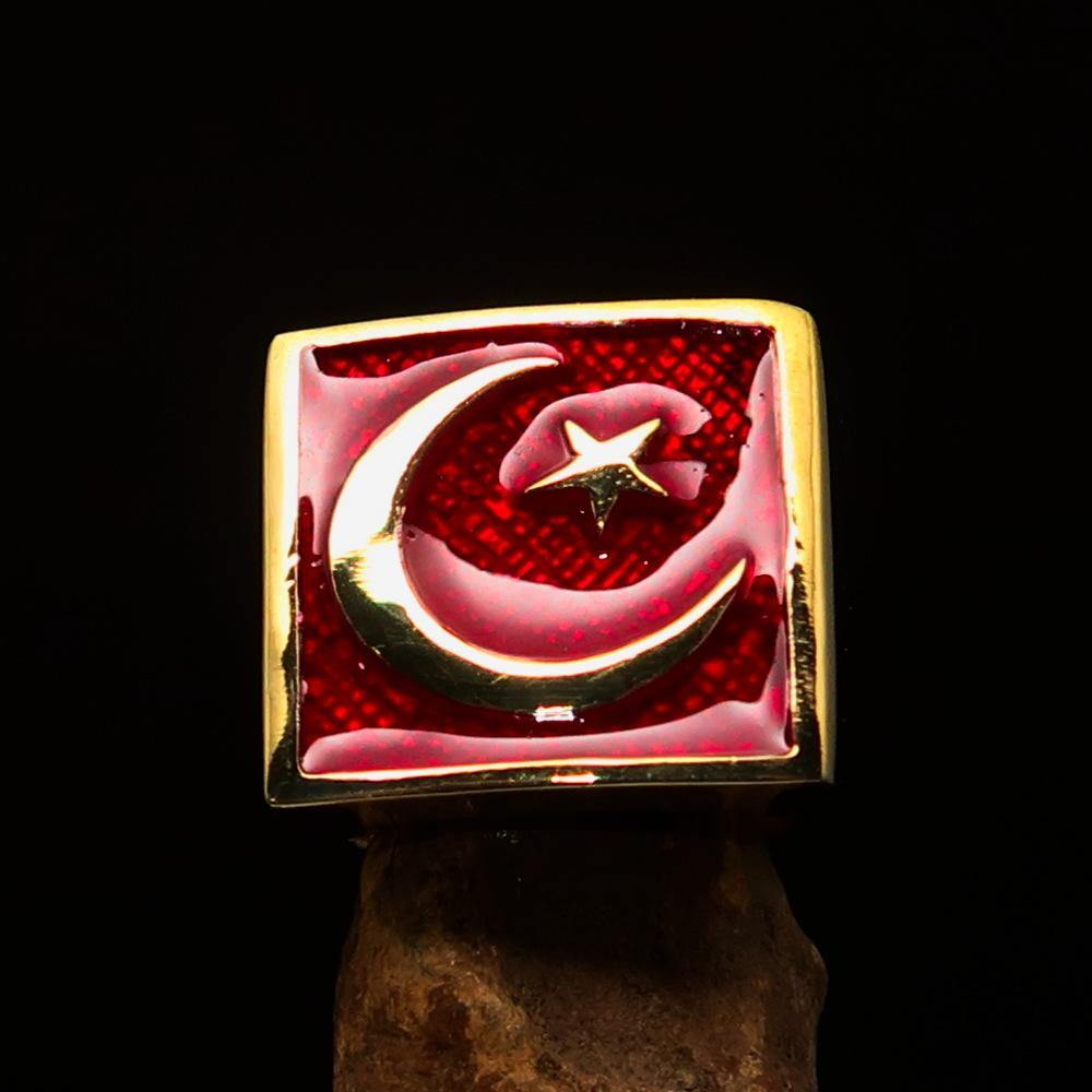 Men's ring made of solid brass featuring a crescent moon and star design with red enamel finish, showcasing its polished surface.