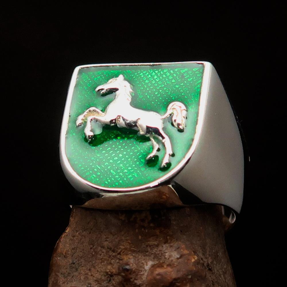 A beautifully crafted sterling silver men's ring featuring a horse coat of arms design with green enamel accents, symbolizing strength and elegance.