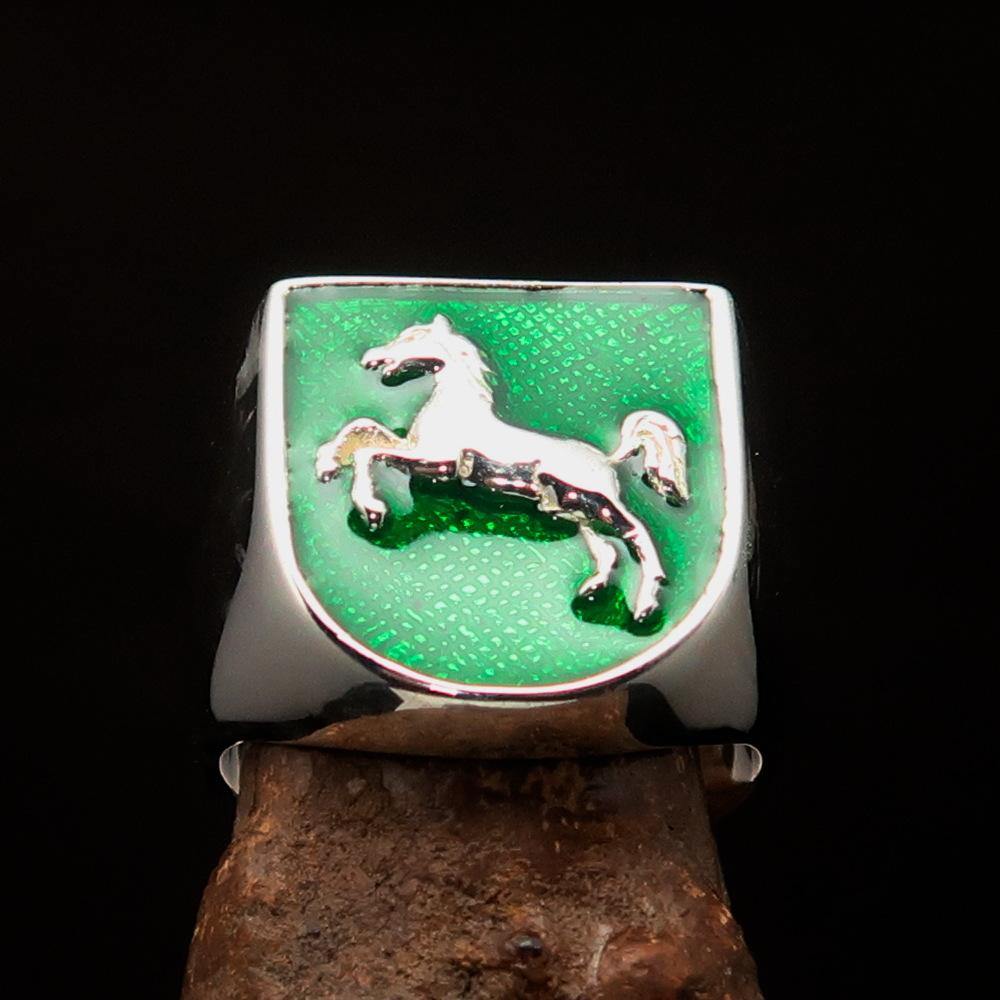 A beautifully crafted sterling silver men's ring featuring a horse coat of arms design with green enamel accents, symbolizing strength and elegance.