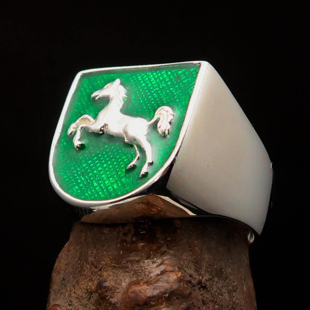 A beautifully crafted sterling silver men's ring featuring a horse coat of arms design with green enamel accents, symbolizing strength and elegance.