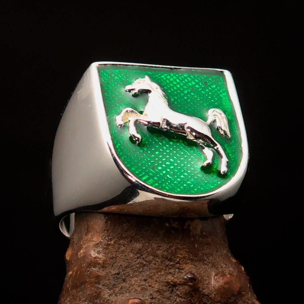 A beautifully crafted sterling silver men's ring featuring a horse coat of arms design with green enamel accents, symbolizing strength and elegance.