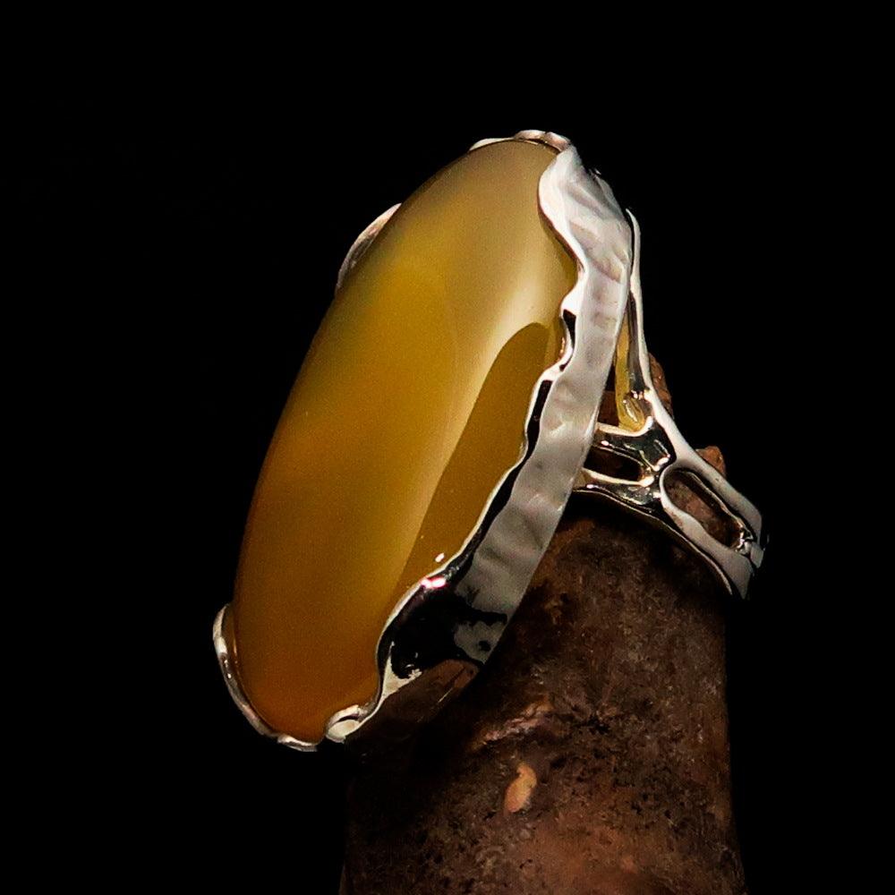 Sterling Silver Artwork Ring featuring an oval yellow Agate Cabochon, polished to a mirror finish, showcasing its vibrant color and elegant design.