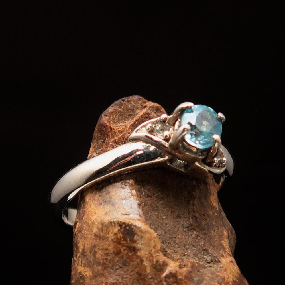 Sterling Silver Solitaire Band Ring featuring an oval cut blue Zircon and two white CZ stones, polished to a mirror finish.