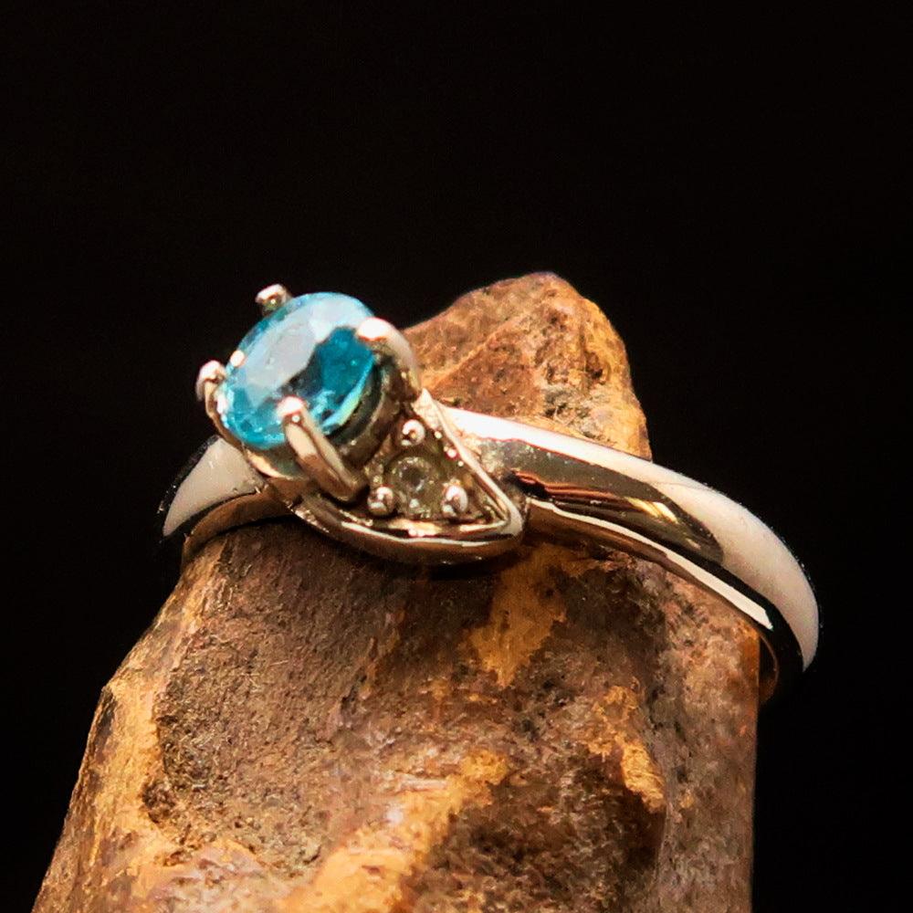 Sterling Silver Solitaire Band Ring featuring an oval cut blue Zircon and two white CZ stones, polished to a mirror finish.