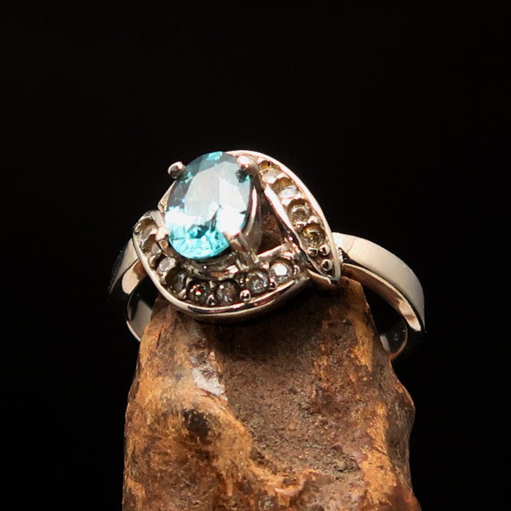 Sterling Silver Solitaire Ring featuring an oval cut blue Zircon and 16 white CZ stones, hallmarked 925.