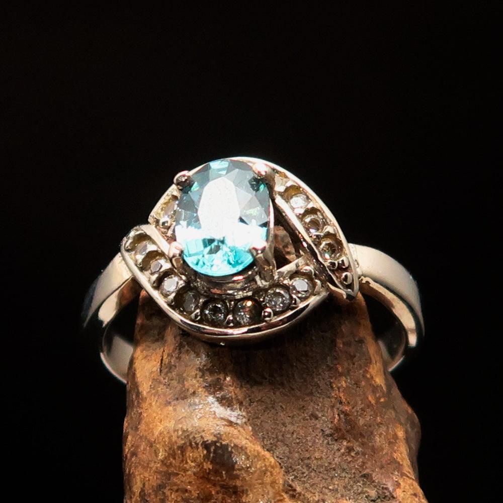 Sterling Silver Solitaire Ring featuring an oval cut blue Zircon and 16 white CZ stones, hallmarked 925.