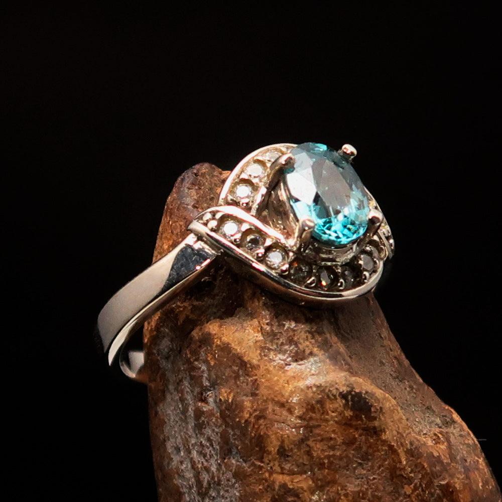 Sterling Silver Solitaire Ring featuring an oval cut blue Zircon and 16 white CZ stones, hallmarked 925.