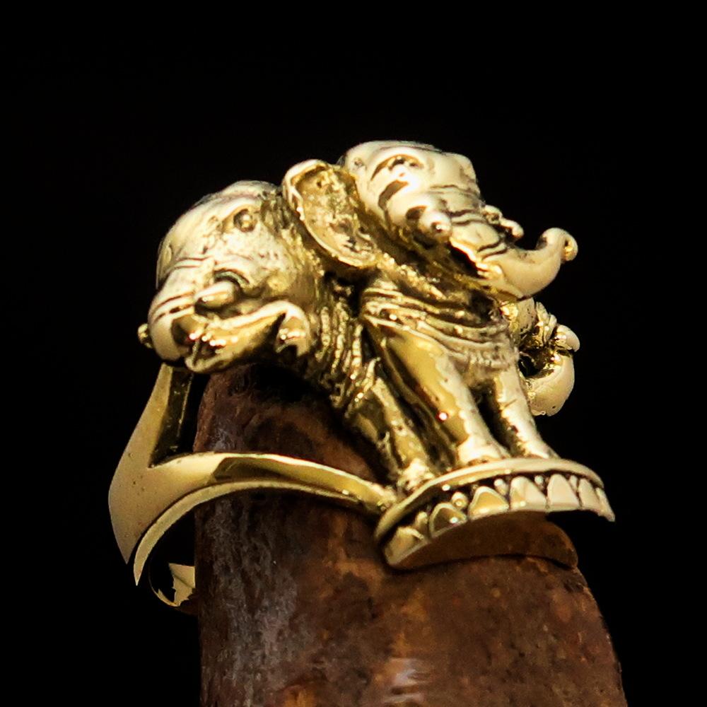 A stunning men's brass ring featuring an intricately designed three-headed elephant, showcasing its polished and antiqued finish.